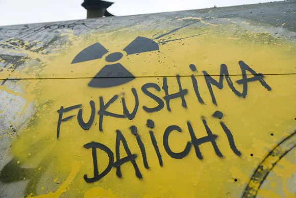 Scritta Fukushima Daiichi con simbolo del nucleare su un serbatoio giallo