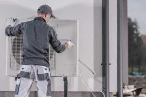 Uomo che installa un condizionatore efficiente e a risparmio energetico