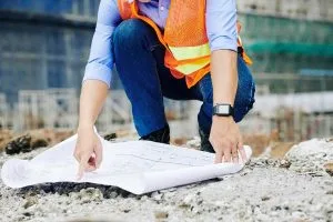 persona in un cantiere di costruzioni con terreno inerte da buttare nei rifiuti intorno